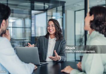 Shot of group of business persons in business meeting. Three entrepreneurs on meeting in board room. Corporate business team on meeting in modern office. Female manager discussing new project with her colleagues. Company owner on a meeting with two of her employees in her office.